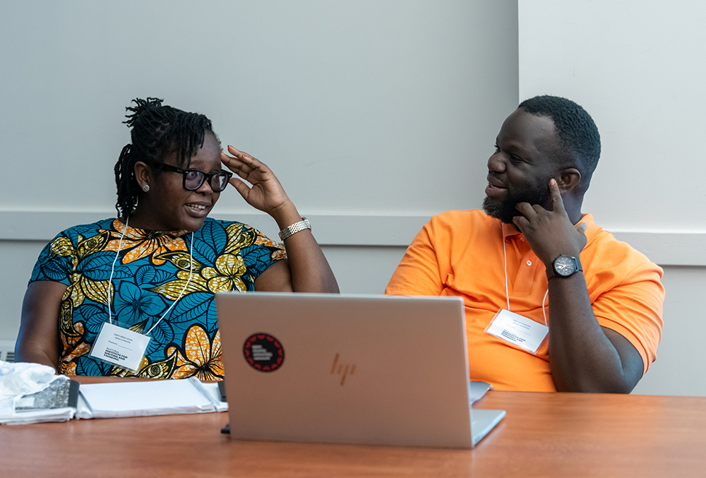 Two professors have a conversation in front of a laptop.; IWT/CLASP Workshop on &quot;Supporting Writing to Learn with Technology&quot;