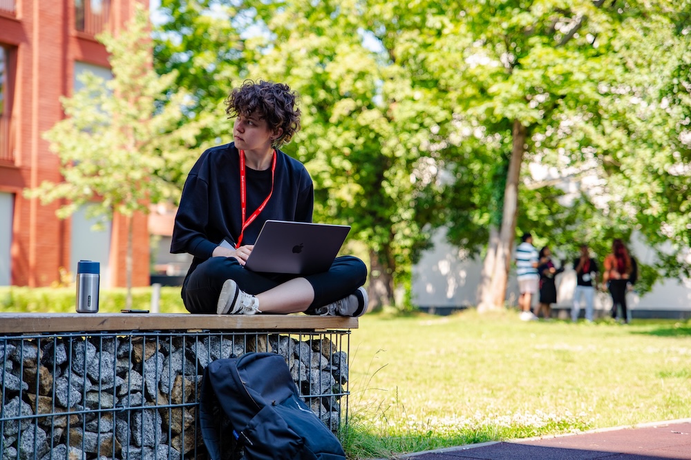 Student working at a laptop outside; Civic Engagement Workshop:&nbsp;How to Find and Use AI Effectively for Implementing Your Project