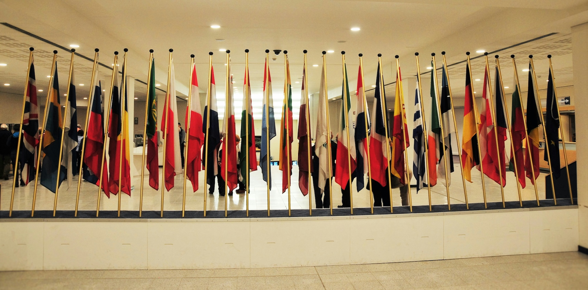 A rowf of glag poles with various flags on them